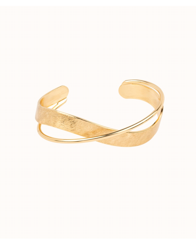 Pulsera rígida chapada en oro 18 Kt con dos tiras cruzadas de diferente textura. Diámetro 60 mm. La elección perfecta para compl